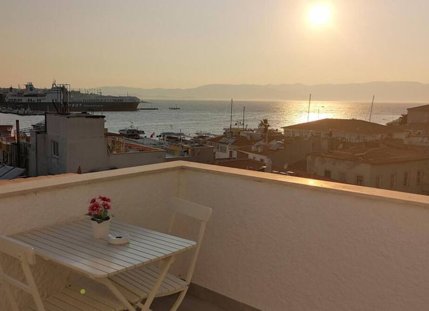 Villa Fanti in Cesme: rooftop terrace with table and chair overlooking the sea at sunset