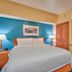 Fairfield Inn & Suites by Marriott Burlington guest room with king bed, teal accent wall, and sitting chair