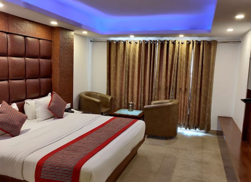 Hotel Hamers International, Mussoorie guest room with king bed, seating area and blue-lit ceiling