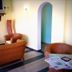 Hotel Mistral in Campo nell'Elba lounge with wicker chairs, TV, side table and arched doorway