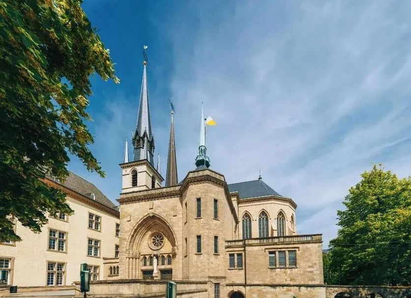 La Pipistrelle Hotel in Luxembourg with historic stone facade, twin spires, and trees