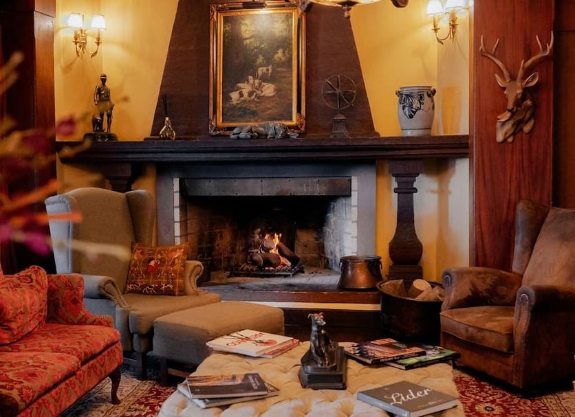 Hotel Casa da Montanha in Gramado lounge with fireplace, ornate decor, and vintage seating