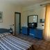 Resort Itaca - Nausicaa room in Rossano with striped bed, blue desk and mirror