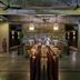 Templation Hotel in Siem Reap lobby bar with long central table, pendant lights, and concrete ceiling fans