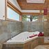 The Cabins at Terrace Beach in Ucluelet bathroom with jetted tub, walk-in shower and wood ceiling