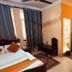 Om Mandakini Hotel Kathmandu guest room with two beds, desk, wardrobe and window curtains