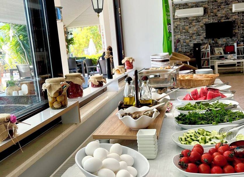 Villa Anfora, Datça: buffet table with eggs, tomatoes, greens and fruit in a dining area
