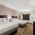 Americas Best Value Inn Byhalia guest room with two beds, TV, window, and carpeted floor