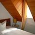 Bayerischer Hof Münnerstadt guest room with bed, sloped wood ceiling, and sunlit window