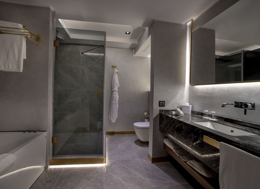 The Wings Hotels Karakoy bathroom in Istanbul with walk-in shower, bathtub, and double vanity