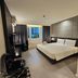 The Park Residence Bangkok guest room with king bed, desk, chair and city view window