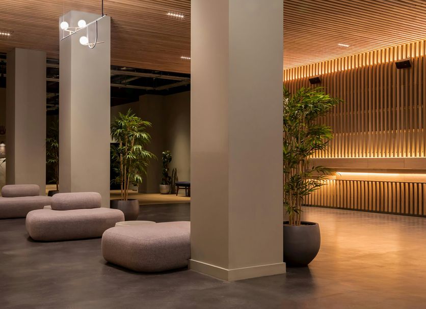 Zedwell Piccadilly Circus lobby in London with lounge seating, tall columns and warm wood slat lighting