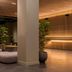 Zedwell Piccadilly Circus lobby in London with lounge seating, tall columns and warm wood slat lighting