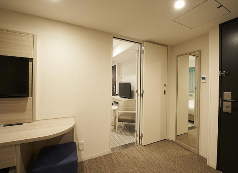 Sotetsu Fresa Inn Ginza-Sanchome room in Tokyo with desk, TV, and open doorway to another space