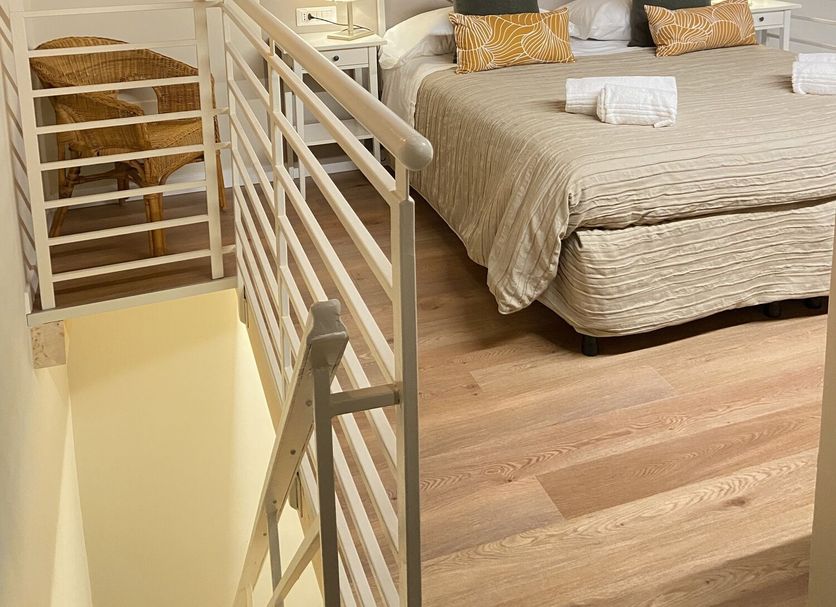 Soggiorno Alessandra Florence room with double bed, wood beams and staircase railing
