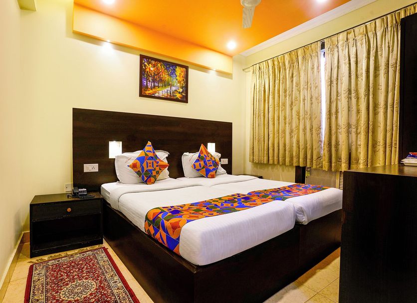 Fabhotel Manoshanti - Nr. Big Daddy Casino in Panaji room with double bed, colorful bedding and curtains