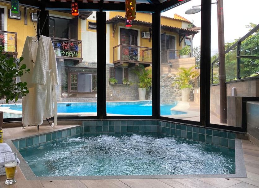 Hotel Casa Encantada in Penedo: indoor hot tub beside an outdoor pool with courtyard balconies