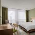 flexymotel Buchs guest room with bed, chair, desk and large window with curtains