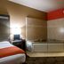 Best Western Executive Inn El Campo room with corner jetted tub, bed, and vanity sink area