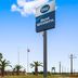 Best Western Executive Inn El Campo roadside exterior with palm trees and a large sign
