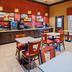 Breakfast area at Best Western Executive Inn El Campo with tables, chairs, and coffee station