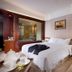 Shuguang Liting Hotel Ningbo guest room with a bed, sitting area, and floor lamp