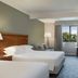 Delta Hotels by Marriott Waltham Abbey guest room with two beds, desk, and window view