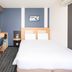 Comfort Hotel Narita room with bed, desk, wall-mounted TV and compact seating area in Narita