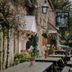The Falkland Arms in Chipping Norton with rustic outdoor tables along a stone courtyard path