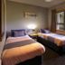 Haka Lodge Christchurch twin room with two single beds and a large window overlooking trees