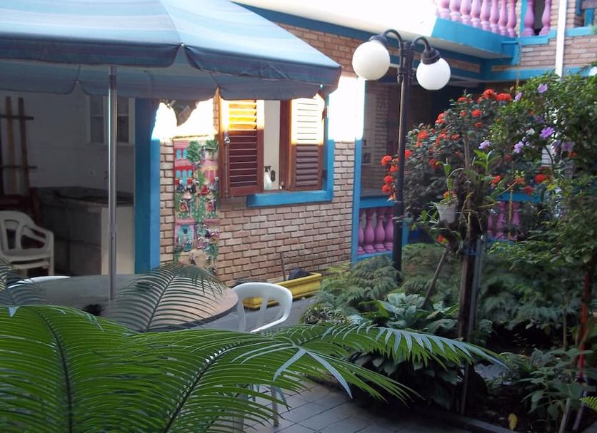 Pousada Riacho Doce in Caraguatatuba, courtyard garden with patio seating and brick facade
