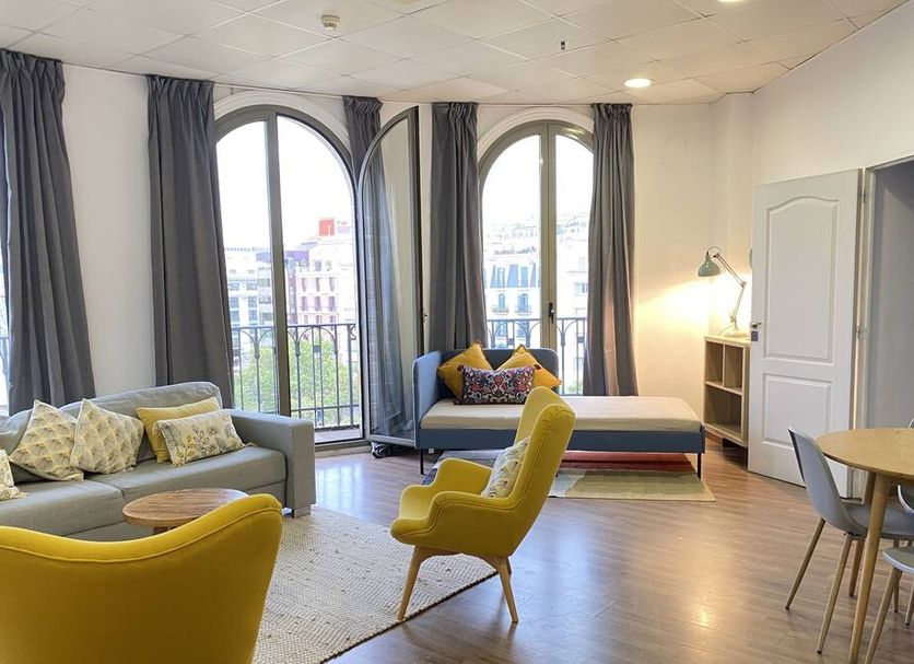 Safestay Barcelona Passeig de Gracia lounge with arched windows and city view in Barcelona