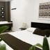 Ocean Breeze Santo Domingo guest room with king bed, vanity desk and wall art