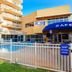 Pelican Beach Resort & Conference Center in Destin with poolside cafe and outdoor seating behind a white fence