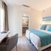 Invisa Hotel Es Pla - Adults Only room in Sant Antoni de Portmany with bed, desk and beach artwork