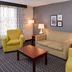 La Quinta Inn & Suites by Wyndham Indianapolis South guest room with sofa, chairs, coffee table and lamps