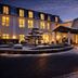 Hotel Sonne in Rheda Wiedenbrueck exterior at dusk with lit windows, entrance canopy and lanterns