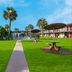 Red Roof Inn Vero Beach - I-95 in Vero Beach with palm-lined lawn, walkway, and picnic tables
