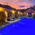 Las Brisas Resort and Villas in Jacó, pool courtyard at sunset with lounge chairs and gazebo