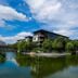 Wuxi Idea Garden Hotel in Wuxi beside a tranquil lake with trees and skyline reflections