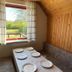 Grindsted Aktiv Camping dining nook with window view of greenery and a long table in Grindsted