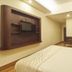 Rkn Hotel Pondicherry guest room with double bed, wall-mounted TV nook, and wooden wardrobe