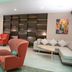 Holiday Inn Metairie New Orleans lobby lounge with red chairs, sectional sofa and shelving