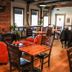 Old Mill Inn, Hatfield: cozy lounge with red armchairs, wooden tables, brick fireplace and bar seating