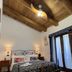 Agriturismo La Casa Del Ghiro in Pimonte bedroom with wood-beamed ceiling, bed, and balcony doors