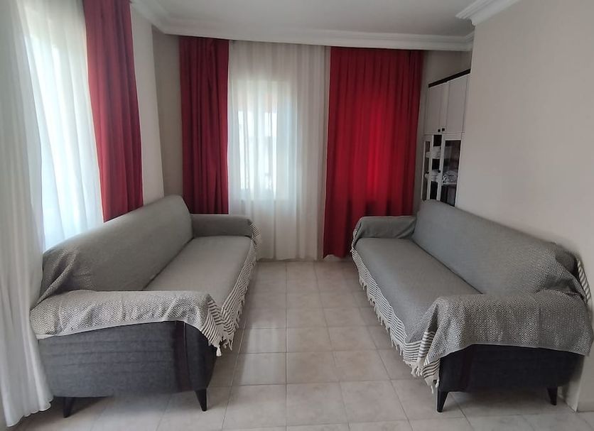 Villa Dream Apart Hotel in Marmaris: bright room with two gray sofas and red curtains