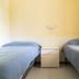 Del Garda Village and Camping in Peschiera del Garda, twin beds and bedside cabinet in a simple guest room
