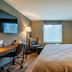 Four Points by Sheraton Brunswick guest room with king bed, desk, chair, and window