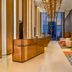 Capri by Fraser, Bukit Bintang lobby in Kuala Lumpur with gold reception desk and tall city-view windows