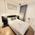 AYZ Javier Cabrini in Madrid: simple double room with bed, bedside table, wall art and standing fan
